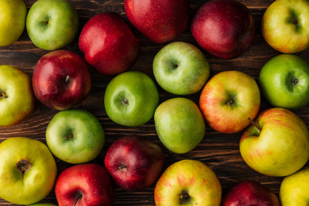 pohled shora zralé vícebarevné jablek na dřevěný stůl - Fotografie, Obrázek