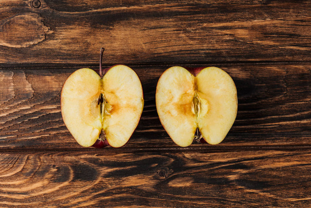 vista superior de las mitades de manzanas maduras cortadas en mesa de madera
 - Foto, Imagen