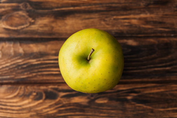 vista superior de la manzana dorada madura deliciosa sobre mesa de madera
 - Foto, Imagen