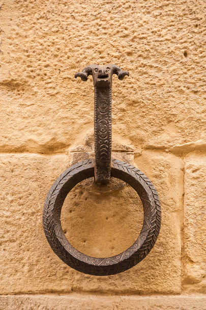 Παλιό δαχτυλίδι επεξεργασμένου σιδήρου για την πρόσδεση άλογα με το κεφάλι της μνήμης ram, σε έναν πέτρινο τοίχο μπλοκ - Φωτογραφία, εικόνα