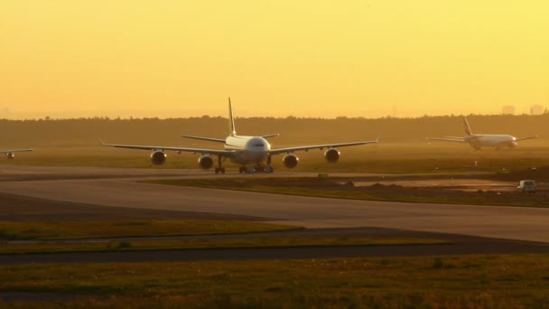 Літак на Руліжна доріжка після заходу сонця на Франкфуртському аеропорту Німеччина - Кадри, відео