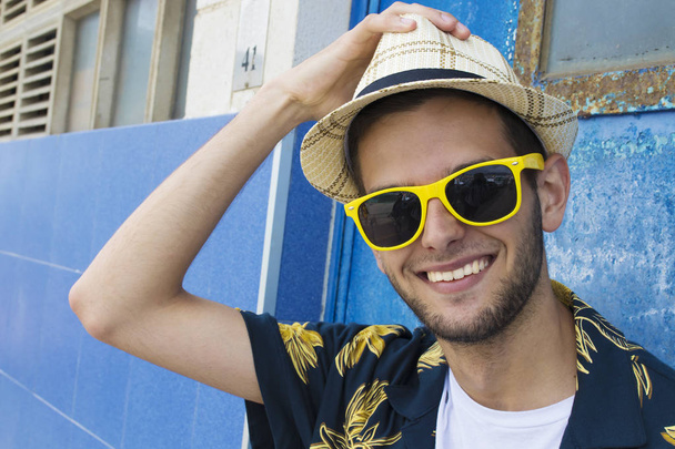 portrait de jeune homme souriant avec lunettes de soleil et chapeau
 - Photo, image
