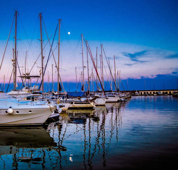 Boote im Hafen von Castelldefels bei Sonnenuntergang. können Sie die Reflexionen der Boote für die Ruhe der Umgebung sehen. der Hafen ist Port Ginesta - Foto, Bild