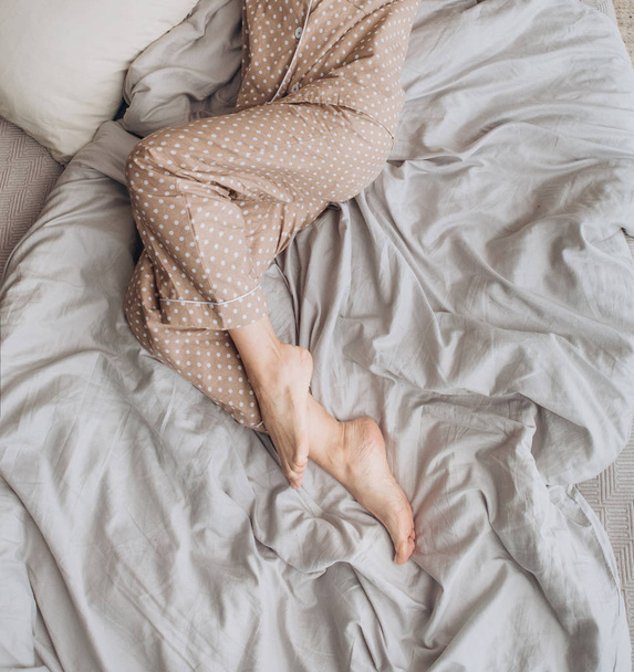 girl in pajamas sleeping on a bed with pillows decor christmas tree light - Valokuva, kuva