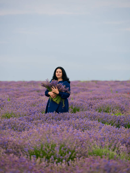 Young girl in blue dress, posing in a lavender field. - Фото, изображение