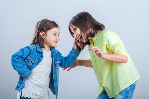 Konflikt zwischen Schwestern, jüngere Schwester zieht ältere Schwester an den Haaren. - Foto, Bild