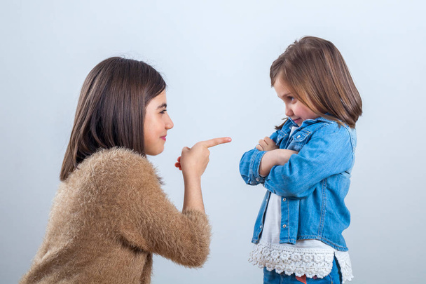 older sister gives a remark to the younger one with a finger. - Φωτογραφία, εικόνα