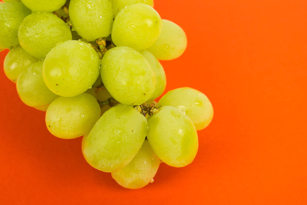 Спелый зеленый виноград на красном фоне
  - Фото, изображение