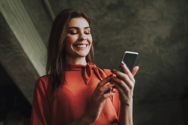 Smiling business woman reading messages on phone - Valokuva, kuva
