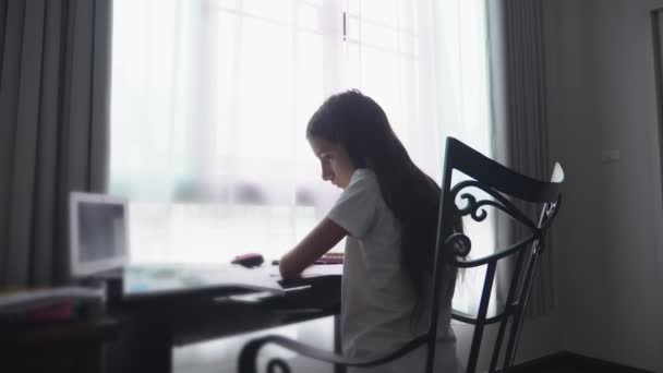 Teenage girl doing homework for school in her room, on the desk - Кадри, відео