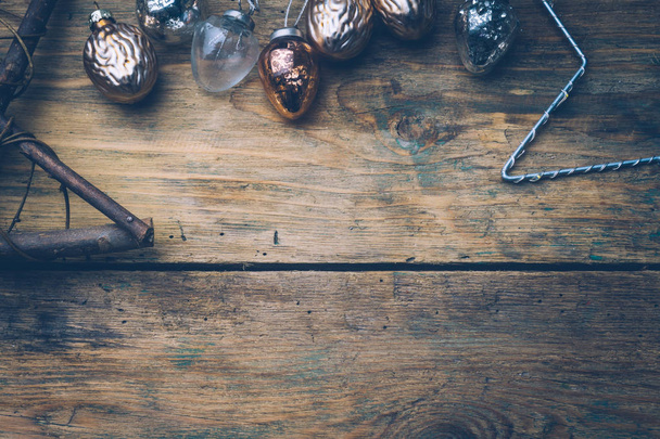 Año Nuevo o Navidad fondo moderno con decoraciones navideñas en plata, oro y color rosa. Los juguetes navideños los colores pastel sobre la mesa de madera: las estrellas y las bolas. Plano, vista superior, espacio para copiar
 - Foto, Imagen