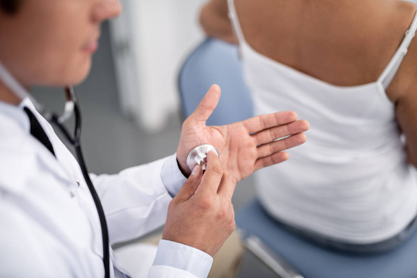 Spokojny lekarz zakładanie jego ręka stetoskop - Zdjęcie, obraz