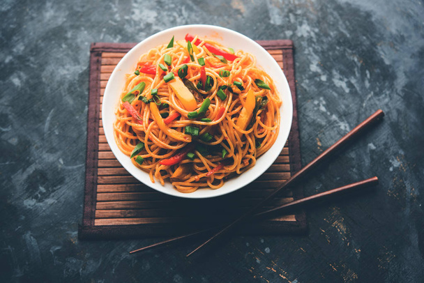 Schezwan nudle nebo zeleniny Hakka nudle chow mein je populární Indo-čínské recepty, podávané v misku nebo talíř s dřevěnými hůlkami. Selektivní fokus - Fotografie, Obrázek