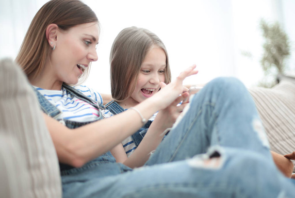 close up.happy mom and her daughter are watching videos on smartphone - Fotoğraf, Görsel