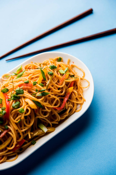 Schezwan nudle nebo zeleniny Hakka nudle chow mein je populární Indo-čínské recepty, podávané v misku nebo talíř s dřevěnými hůlkami. Selektivní fokus - Fotografie, Obrázek