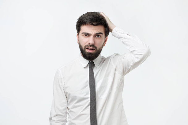 Handsome spanish man with beard scratching head while being puzzled or clueless - Photo, Image