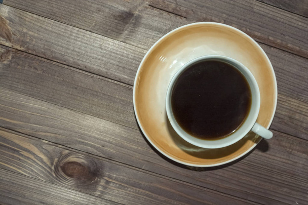 a Cup of coffee on a dark wooden table. - Foto, Bild