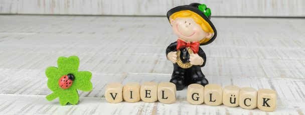 Kleine schoorsteen veger met een klavertje van vier en de Duitse woorden voor goed geluk - Foto, afbeelding