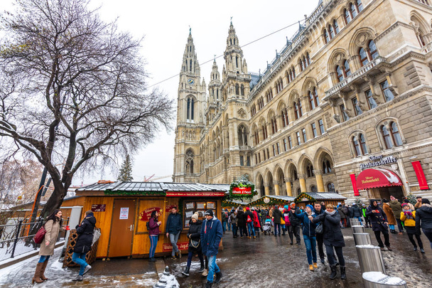 Vienna, Austria - 1.12.2018: Vienna christmas market, Austria. Traditional christmas event in Austria capital. Sale on the main town hall and square. Tourist, peoples and customers in small shop. - Zdjęcie, obraz