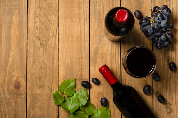 Бутылки вина Кубок связка винограда на деревянном фоне. Вид сверху с пространством для копирования
 . - Фото, изображение