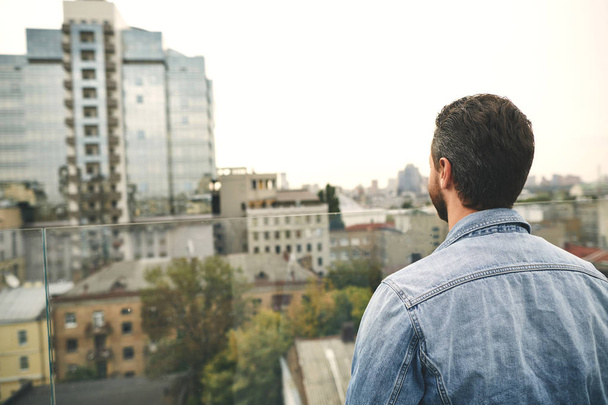 Man is standing outdoor and looking on city - Foto, Imagen