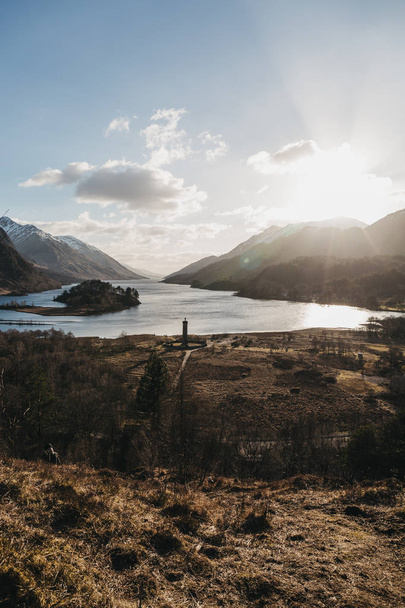 View of the Glenfinnan Monument, Loch Shiel and Scottish landscape near Glenfinnan, Inverness-shire, Scotland, on a cold spring sunny day. - Photo, Image