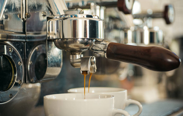 Vorbereitung bis zur Perfektion. kleine Tassen zum Servieren von heißen Kaffeegetränken. Kaffeetassen. Kaffee, der in einem Kaffeehaus oder Café gebrüht wird. Kaffee brauen mit Espressomaschine. Espresso zubereiten mit Portafilter - Foto, Bild