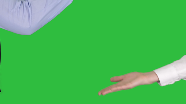 De cerca. Manos negras masculinas y blancas femeninas dando cinco bajas en una pantalla verde, Chroma Key. Tiro profesional en resolución 4K. 012. Puede usarlo, por ejemplo en su vídeo comercial, médico, de negocios
 - Imágenes, Vídeo