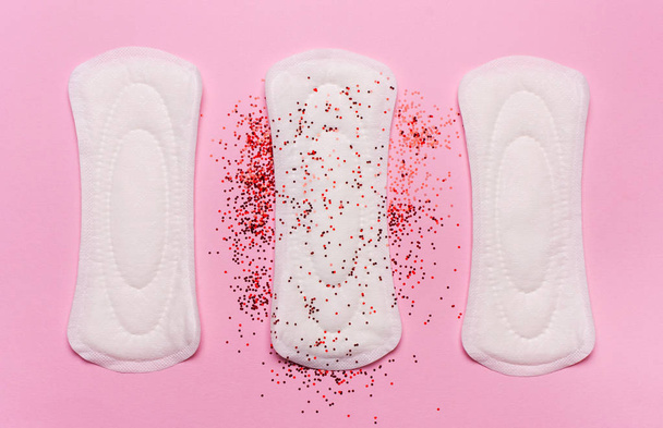 Productos de higiene de las mujeres sobre un fondo rosa. Concepto de días críticos, ciclo menstrual, menstruación
 - Foto, Imagen