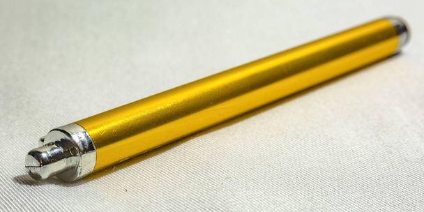 Caneta stylus amarela em uma superfície texturizada branca
 - Foto, Imagem