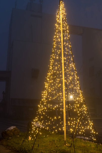 große LED-Lichterkette beleuchtet Weihnachtsbaum als Dekoration für den Außenbereich - Weihnachtsbaum - Foto, Bild