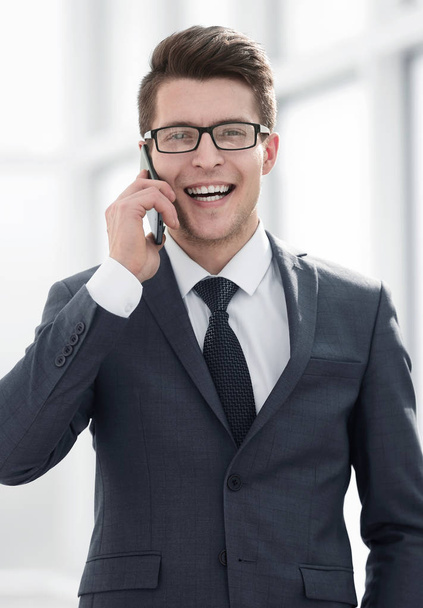 smiling young businessman talking on smartphone - Foto, afbeelding