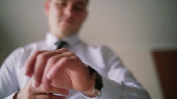 A man groom wears a watch on his arm. - Felvétel, videó