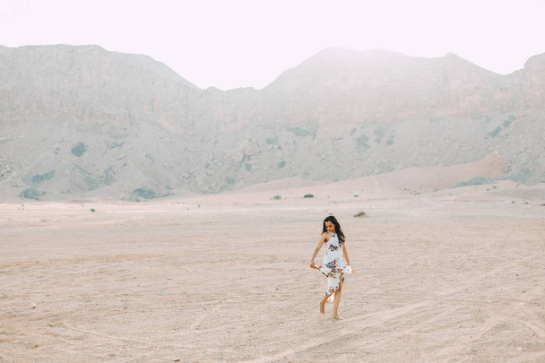 Młoda kobieta indyjska w białej długiej sukni chodzenie na pustyni - Zdjęcie, obraz