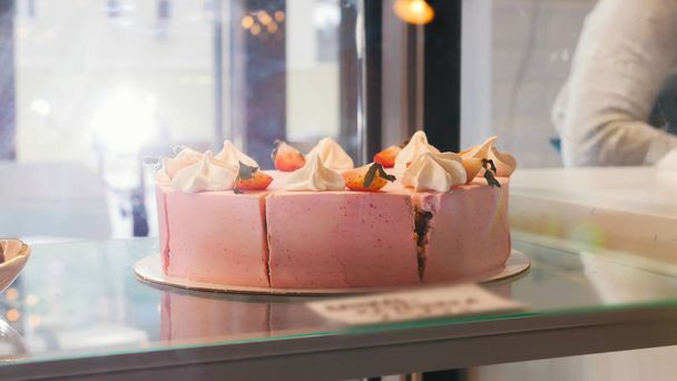Красивый розовый торт за витриной магазина
. - Фото, изображение