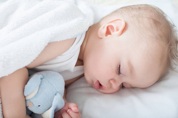 Beautiful baby boy laying down in his bed and sleeping. Close up. - 写真・画像