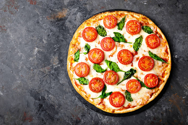 Pizza Margherita with mozzarella cheese, basil and tomatoes Traditional italian food. Classic recipe. Top view - Photo, image