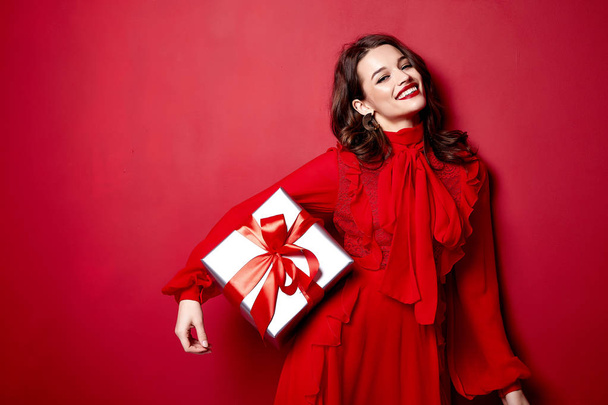 Beautiful young sexy woman thin slim figure evening makeup fashionable stylish dress clothing collection, brunette, gifts boxes red silk bows holiday party birthday New Year Christmas Valentine's Day. - 写真・画像