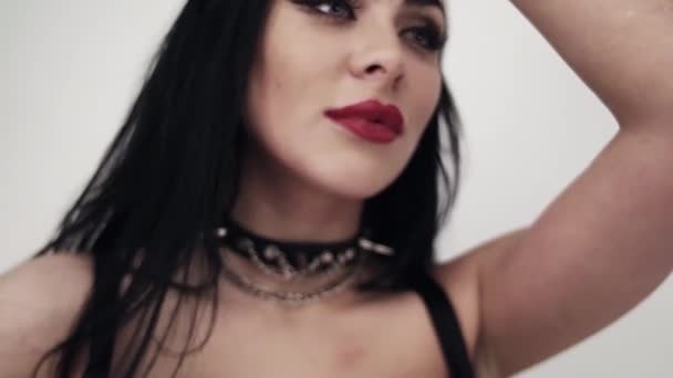 Hot brunette female wearing leather clothes with tattoo and gothic makeup - Footage, Video