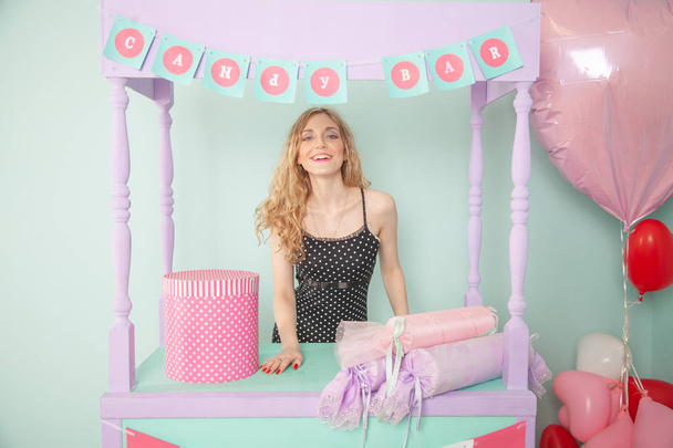 Bella ragazza caucasica in piedi vicino alla sua caramella vuota vendere bancarella con scatola regalo rosa
  - Foto, immagini