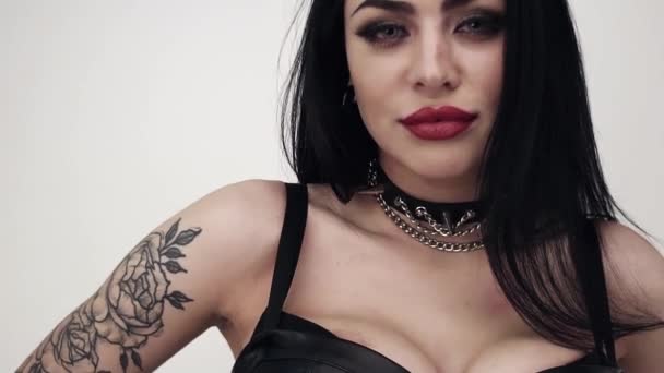 Face of brunette female wearing black leather with big lips and gothic makeup - Footage, Video