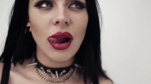 Gesicht des sexy Mädchens mit großen Lippen, niedlichen blauen Augen, langen schwarzen Haaren und Make-up. - Filmmaterial, Video