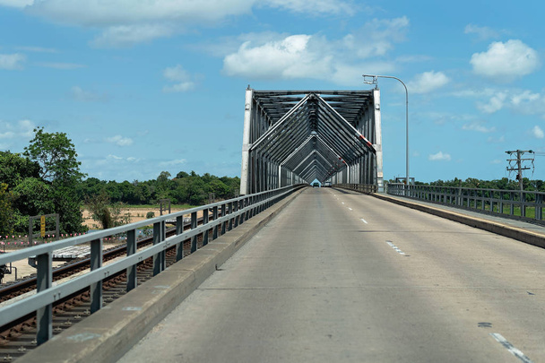 Grande struttura a ponte quadrata in acciaio su strada bituminosa
 - Foto, immagini