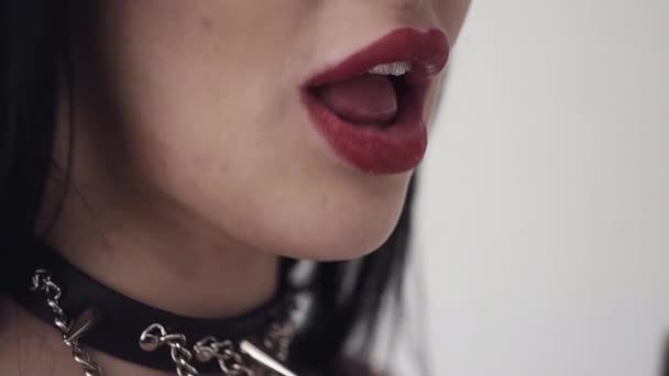 Cute girl with sexy lips, big blue eyes, long black hair and makeup eats orange - Footage, Video