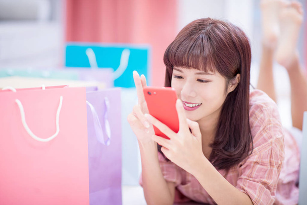 Young woman shopping on the internet with smart phone at home - Фото, изображение