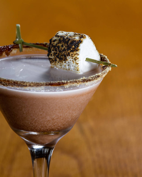 chocolate cocktail with marshmallow vodka garnished with a gram cracker rim and a toasted marshmallow - Photo, image