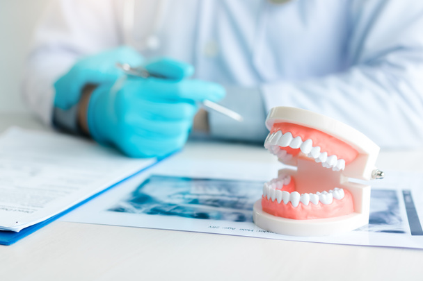 Close-up van kunstgebitten met tandarts werken op tafel in kliniek. - Foto, afbeelding