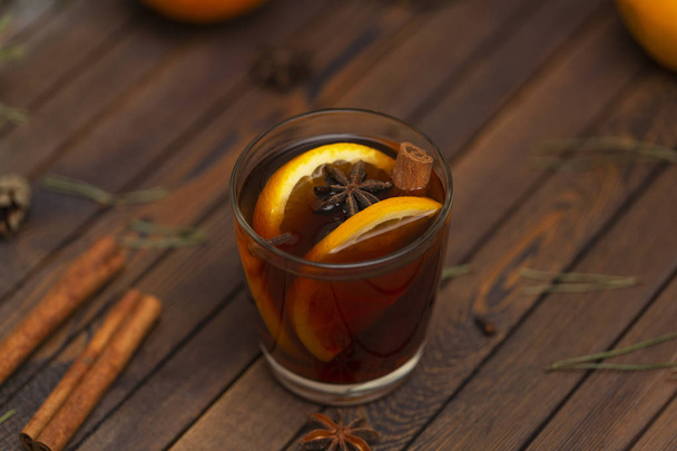 Christmas mulled red wine with spices on a wooden rustic table. Traditional hot drink at Christmas time - Foto, Bild