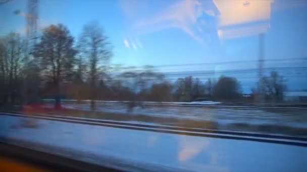 4 k punktu widzenia z okna pociągu pasażerskiego. Opuszczony Zima Las porusza się za oknem - Materiał filmowy, wideo