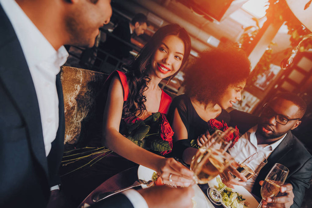 Group Happy Friends Enjoying Dating in Restaurant. Double Couple Dating in Restaurant. Romantic Couple in Love Dating. Friends in a Restaurant Making Order. Romantic Concept. Pouring Glasses Wine - Foto, immagini